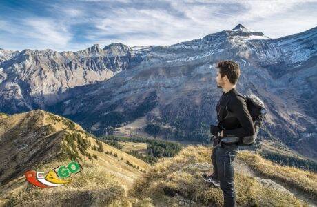 Хлопець стоїть з рюкзаком на плечах у горах