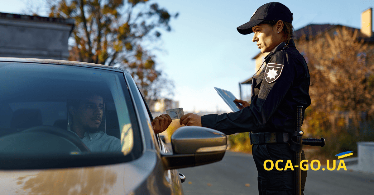 Дівчина-поліцейський перевіряє документи у водія в сірому автомобілі